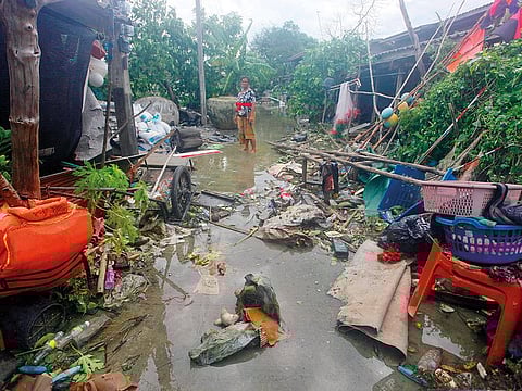 A woman stands amid debris in the aftermath of Tropical Storm Pabuk yesterday in Pak Phanang, in the province of Nakhon Si Thammarat, southern Thailand.