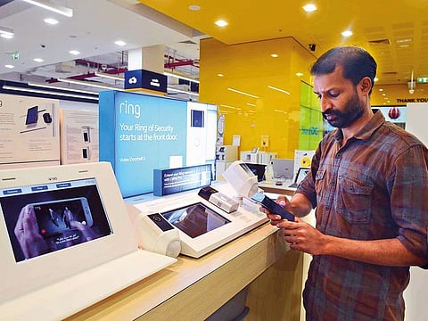 A customer tries a new doorbell product with a hidden camera at Sharaf DG. In the UAE more people are investing in smart cameras, motion sensors and doorbells, experts say.