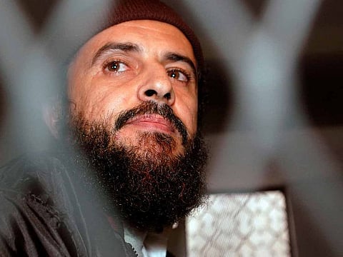 Jamal Al Badawi looks from behind bars during the session of a Sana'a court of appeals hearing in Yemen December 8, 2004.