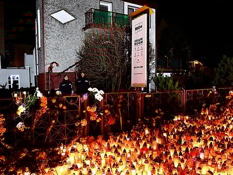 Lights, flowers and toys are left outside the escape room entertainment site where five teenage girls died in a fire last week, in Koszalin, northern Poland, on Sunday, Jan. 6, 2019.