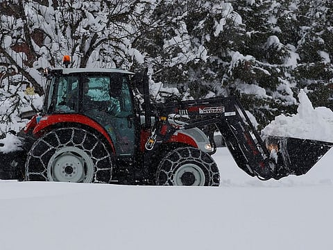 A tractor shovels snow on an icy road after heavy snowfall in Knoppen, Austria January 7, 2019.  