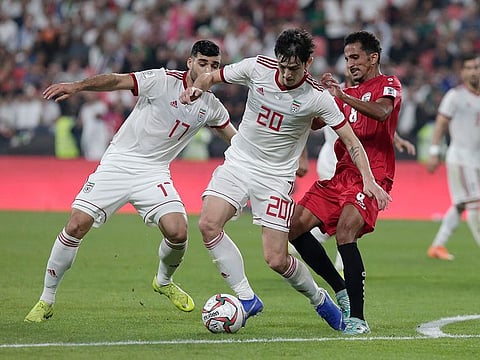 Yemen's midfielder Wahid Al-khyat, right, Iran's forward Sardar Azmoun, center, Iran's forward Mehdi Taremi fight for the ball during the AFC Asian Cup group D soccer match between Iran and Yemen at the Mohammed Bin Zayed Stadium in Abu Dhabi, United Arab Emirates, Monday, Jan. 7, 2019. 