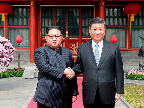 North Korean leader Kim Jong Un, left, shakes hands with Chinese counterpart Xi Jinping at Diaoyutai State Guesthouse in Beijing