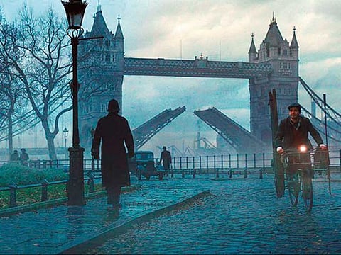 Extras riding bicycles take part in filming of a scene in front of Buckingham Palace.