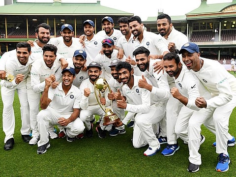 The Indian team pose for a photograph with the Border-Gavaskar Trophy as they celebrate a 2-1 series victory over Australia in Sydney, on January 7, 2019. 