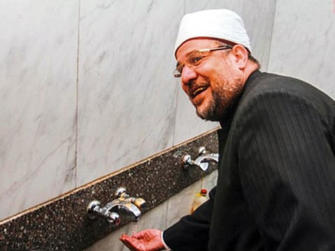 Egyptian Waqfs Minister Mohammad Jumaa tries a watersaving tap at a Cairo mosque.