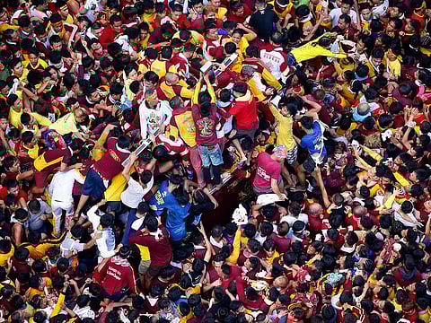 Filipino Roman Catholic devotees jostle to kiss and rub with towels the image of the Black Nazarene in a raucous procession to celebrate its feast day Wednesday, Jan. 9, 2019, in Manila, Philippines.