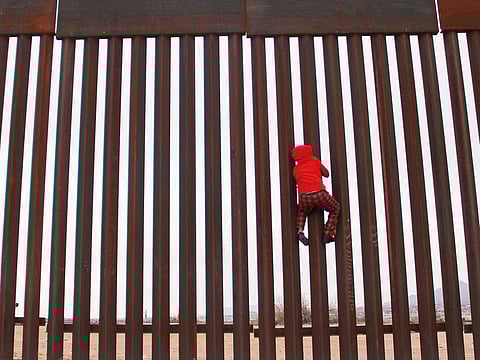 A boy from the Anapra area, playing, climbs the border fence between Sunland Park,  New Mexico, US, and Ciudad Juarez, Chihuahua state, Mexico, on Tuesday.