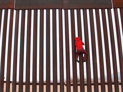 A boy from the Anapra area, playing, climbs the border fence between Sunland Park,  New Mexico, US, and Ciudad Juarez, Chihuahua state, Mexico, on Tuesday.