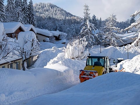 A winter service vehicle removes snow in the cut off Buchenhoehe settlement area in Berchtesgaden, southern Germany, on January 11, 2019. 