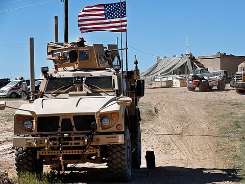 A US soldier sits on an armored vehicle behind a sand barrier near the front line in Manbij, north Syria, in a file photo. 