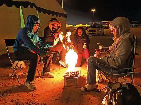 Fun Drive participants unwind next to their tent at the main campsite in Liwa on Friday night. 