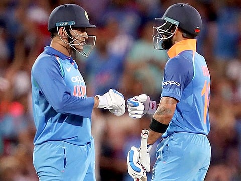 Virat Kohli (right) celebrates his 100 against Australia with teammate M.S. Dhoni during their one day international cricket match in Adelaide, Australia, Tuesday, January 15, 2019. 