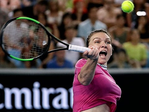 Romania's Simona Halep hits a forehand return to Estonia's Kaia Kanepi during their first round match at the Australian Open tennis championships in Melbourne, Australia, Tuesday, JanUARY 15, 2019. 