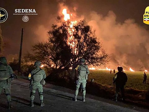 Military personnel watch as flames engulf an area after a ruptured fuel pipeline exploded, in the municipality of Tlahuelilpan, Hidalgo, Mexico, near the Tula refinery of state oil firm Petroleos Mexicanos (Pemex), January 18, 2019 in this handout photo provided by the National Defence Secretary (SEDENA).