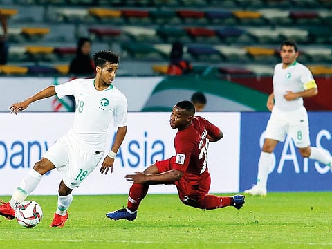 Saudi Arabia’s midfielder Abdulrahman Ghareeb and Qatar’s defender Assim Madibo fight for the ball during the AFC Asian Cup group E soccer match between Saudi Arabia and Qatar
