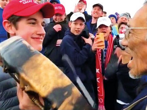 A student from Covington Catholic High School stands in front of Native American Vietnam veteran Nathan Phillips in Washington
