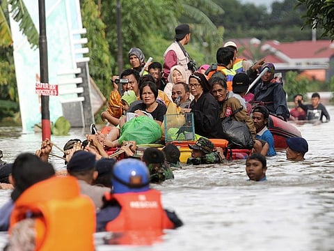 Residents ride a makeshift raft as they evacuate their flooded homes in Makassar, South Sulawesi, Indonesia, Wednesday, Jan. 23, 2019.