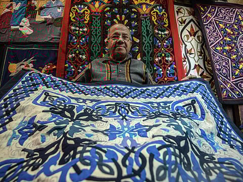 An Egyptian craftsman showcases a tapestry in his shop in Khayamiya Street, Cairo.
