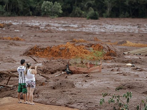 A couple with missing relatives look at the flooded area, after a dam collapsed in Brumadinho, Brazil.