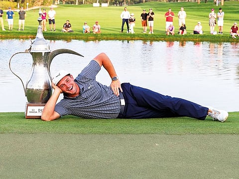 Bryson Dechambeau poses with the winning trophy at the Dubai Desert Classic golf tournament, in Dubai.