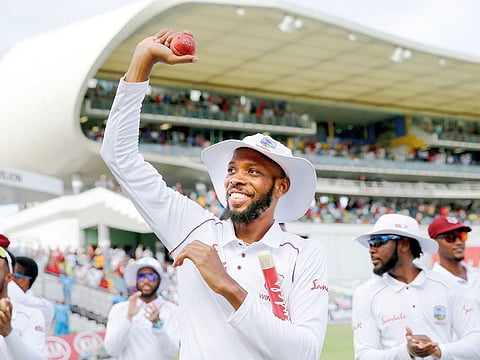 Roston Chase celebrates taking eight wickets against England at the Kensington Oval in Bridgetown, Barbados