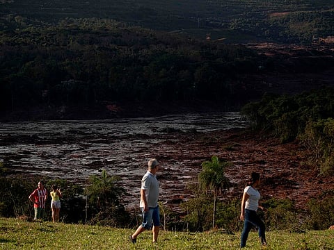 People look at the area around the dam that collapsed two days ago at an iron-ore mine belonging to Brazil's giant mining company Vale near the town of Brumadinho, state of Minas Gerias, southeastern Brazil, on January 27, 2019. 