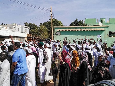 Sudanese protesters chant slogans and raise signs against President Omar al-Bashir 