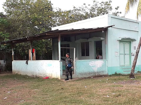 A police investigator stands at the entrance of a mosque in Zamboanga city after a grenade attack