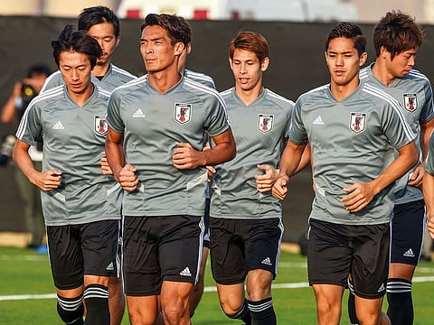 Japan players warm up during a training session yesterday ahead of the AFC Asian Cup final against Qatar at the Zayed Sports City Stadium in Abu Dhabi.