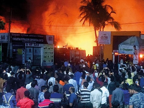 People watch as a major fire breaks out inside the Industrial Exhibition at Nampally in Hyderabad on Wednesday. At least 200 stalls were destroyed in the incident.