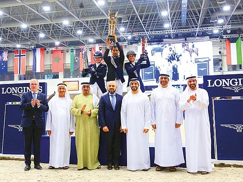 Abdullah Al Muhairi exults on the winner’s podium as officials applaude his victory in the H. H. Ruler of Sharjah Cup.