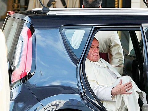 Pope Francis emerges from the back of a Kia Soul following his arrival at the Presidential Palace