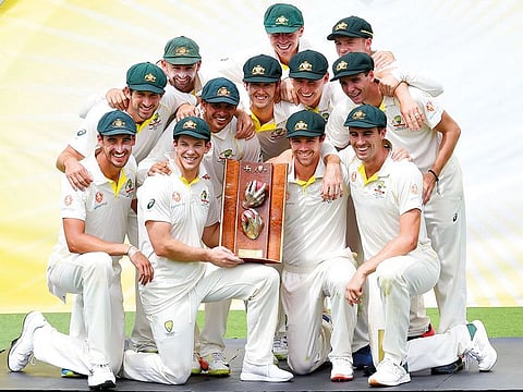 Australian players pose with the winning trophy after defeating Sri Lanka's in the second Test cricket match between Australia and Sri Lanka at the Manuka Oval Cricket Ground in Canberra on February 4, 2019.