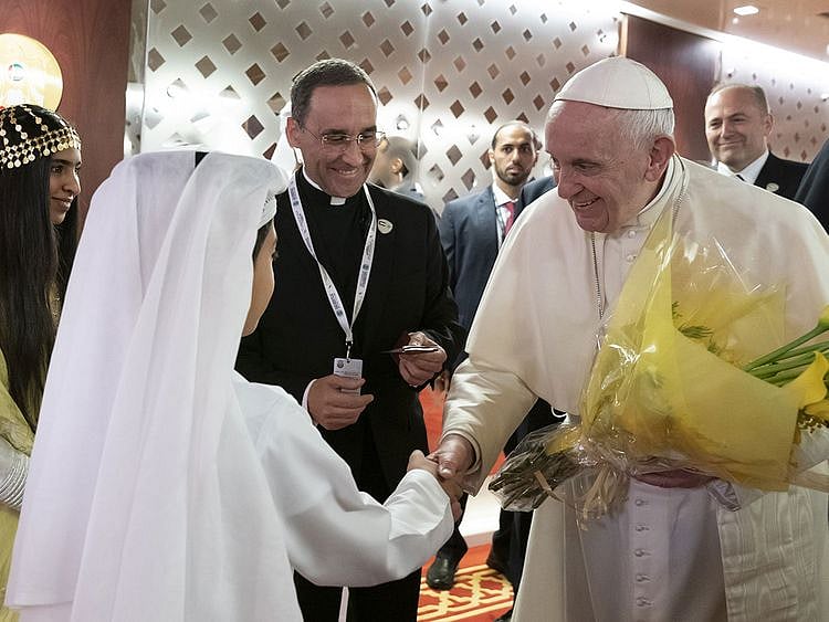 Pope Francis  is greeted by an Emirati boy