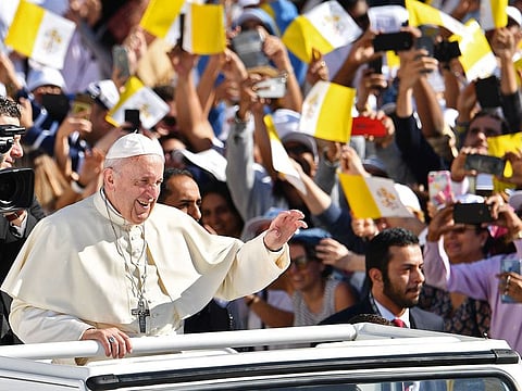 Pope Francis waves to the crowd as he arrives to lead mass Zayed Sports City Stadium in Abu Dhabi. 