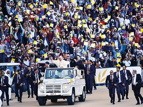 Pope Francis waves to thousands of worshippers at the Zayed Sports City Stadium. 