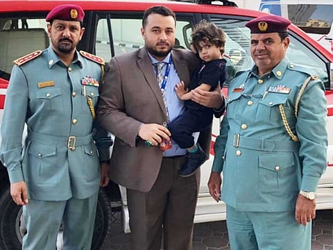 The boy is seen with his father. 