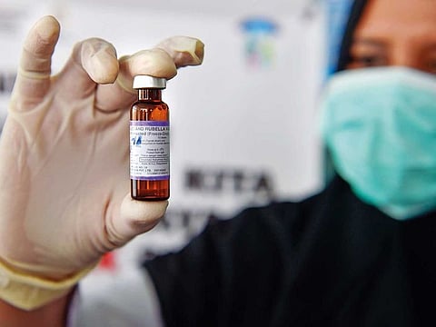 File photo:  A medical worker holds a measles-rubella (MR) vaccine.   