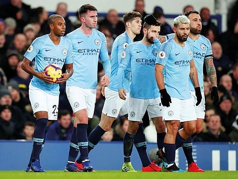 Manchester City players celebrate scoring their first goal during Wednesday’s match with Everton. The champions returned to the top of the table with a 2-0 victory.