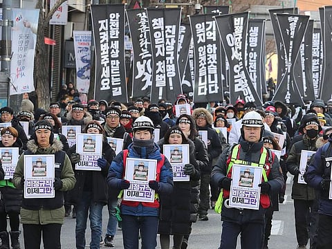 People march to honour a worker crushed to death at a coal plant, in Seoul on February 9, 2019.