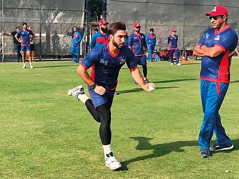 President of Karachi Kings Wasim Akram watches fast bowler Usman Khan bowl during a training session at the ICC Academy.