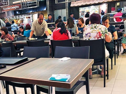 Singaporeans commonly use personal articles such as tissue packets to reserve tables in the city's crowded food courts before purchasing a meal. The practice is considered quintessential "kiasu," which means a fear of losing out.