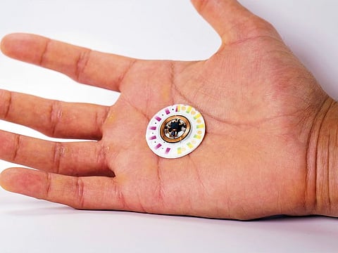 A photo provided by John Rogers, a biomedical engineer at Northwestern University, shows a device — wearable, wireless and battery-free — that reads the body’s toil to monitor the wearer’s health