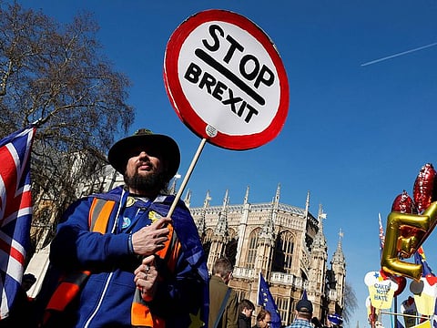 Anti-Brexit activists hold placards as they demonstrate outside of the Houses of Parliament in central London on February 14, 2019.