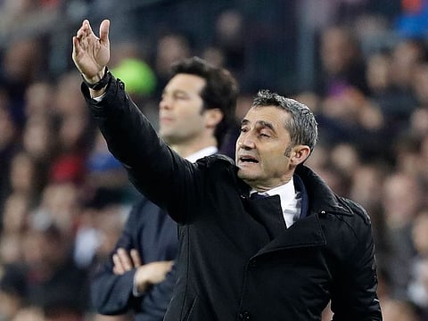 Barcelona coach Ernesto Valverde, front, gives directions as Real coach Santiago Solari, rear, watches his players during the Copa del Rey semifinal first leg soccer match between FC Barcelona and Real Madrid at the Camp Nou stadium in Barcelona, Spain, Wednesday Feb. 6, 2019.