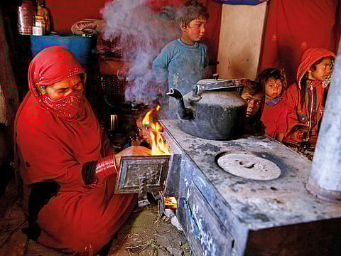 File photo: An internally displaced family warm themselves at a refugee camp in Kabul, Afghanistan.  