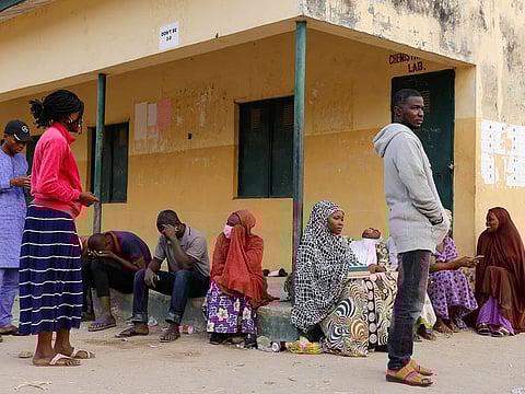 Independent National Electoral Commission (INEC) workers sit outside the Doubeli polling station, after they arrived at the unit unaware of the postponement of the presidential election in Yola, in Adamawa State, Nigeria February 16, 2019.