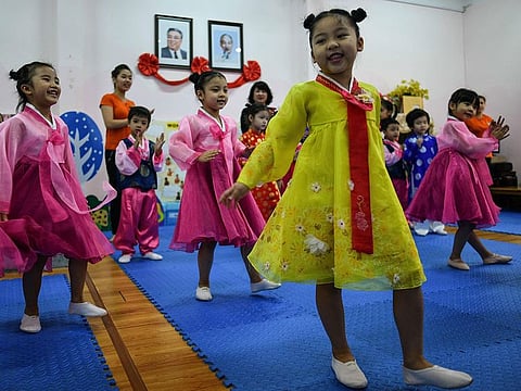 Vietnamese children perform in front of the portraits of the late North Korean leader, Kim Il Sung (L) and Vietnam's Ho Chi Minh (R) at the Vietnam-North Korea Friendship Kindergarten in Hanoi on February 19, 2019. 