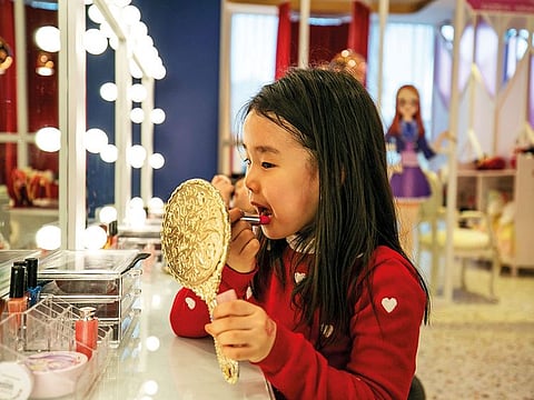 A young girl applies lipstick made for children at PriPara Kids Cafe in Yongin, South Korea
